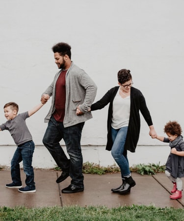 family walking playfully down a path